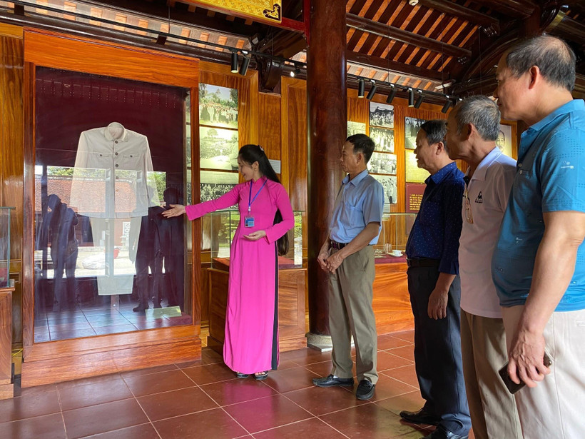 Du khách tham quan và nghe thuyết minh về những kỷ vật về Bác Hồ tại Nhà trưng bày bổ sung tại Khu di tích quốc gia đặc biệt Kim Liên. (Ảnh: Bích Huệ/ TTXVN)