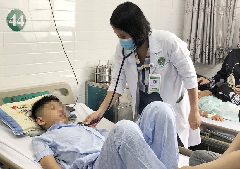 Bác sỹ khám cho các học sinh bị nghi ngộ độc thực phẩm sau khi ăn cơm cuộn bán trước cổng trường. (Ảnh: Đinh Hằng/TTXVN)