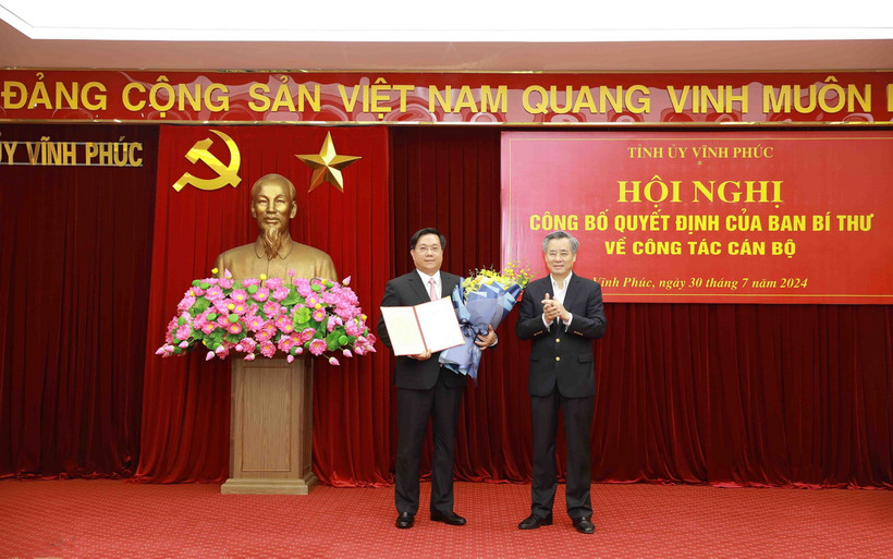 Thứ trưởng Bộ Kế hoạch và Đầu tư Nguyễn Duy Đông (trái) nhận quyết định của Ban Bí thư giữ chức Phó Bí thư Tỉnh ủy Vĩnh Phúc nhiệm kỳ 2020-2025. (Ảnh: Hoàng Hùng/TTXVN)