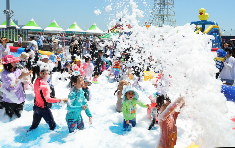Các em nhỏ chơi đùa trong công viên ở Busan, Hàn Quốc trong ngày nắng nóng 29/7/2024. (Ảnh: Yonhap/TTXVN)