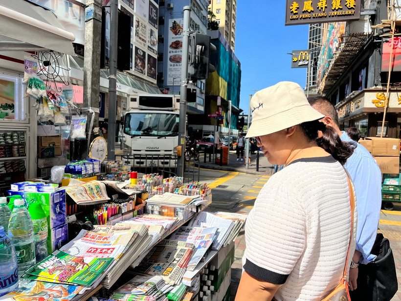 Người dân mua báo tại quầy bán báo trên đường phố Hong Kong (Trung Quốc). (Ảnh: Mạc Luyện/TTXVN)