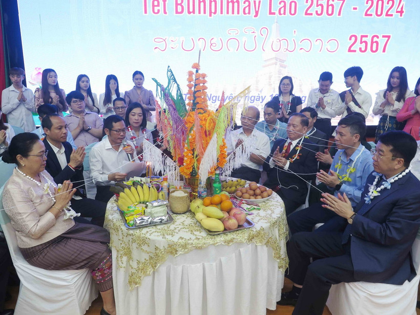 Các đại biểu thực hiện nghi lễ theo phong tục Tết Bunpimay của Lào. (Ảnh: Thu Hằng/TTXVN)