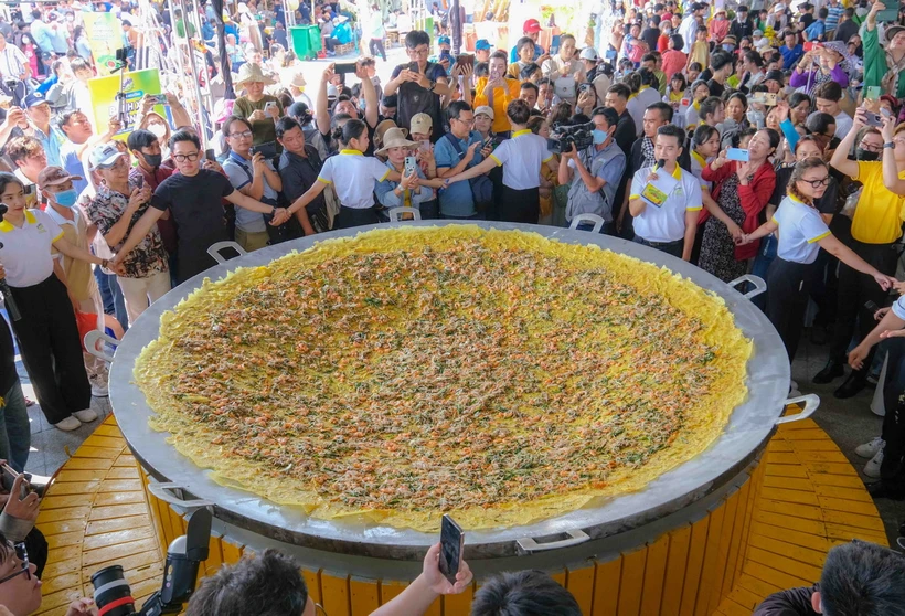 Sau khi hoàn thành, chiếc bánh được chia ra 1.000 phần để chiêu đãi miễn phí khách đến tham quan. (Ảnh: Thanh Liêm/TTXVN)