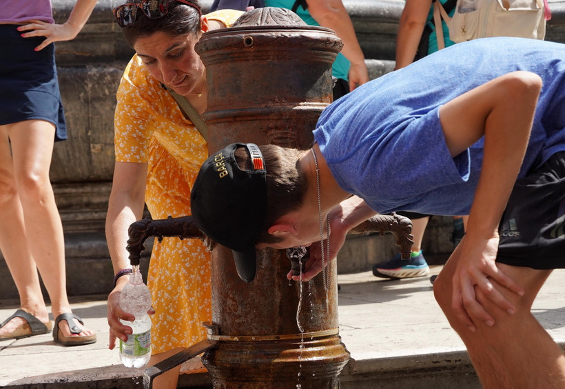 Người dân uống nước để giải nhiệt tại Rome, Italy, ngày 18/7/2023. (Ảnh: THX/TTXVN)