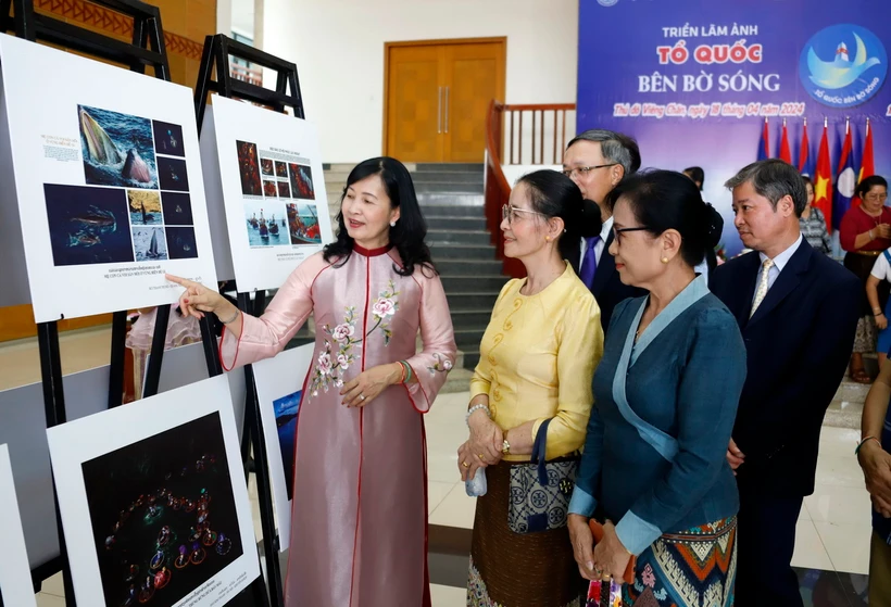Bà Trần Thị Thu Đông, Phó Chủ tịch Liên hiệp các hội Văn hóa Nghệ thuật Việt Nam, Chủ tịch Hội Nghệ sĩ Nhiếp ảnh Việt Nam giới thiệu các bức ảnh với khách tham quan Triển lãm. (Ảnh: Phạm Kiên/TTXVN)