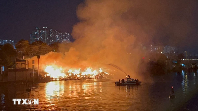 Cảnh sát Phòng cháy chữa cháy sử dụng ca nô chuyên dụng để phun nước vào đám cháy. (Ảnh: TTXVN)