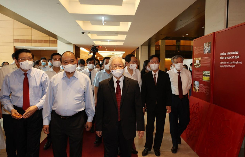 Tổng Bí thư Nguyễn Phú Trọng, Chủ tịch nước Nguyễn Xuân Phúc, Thường trực Ban Bí thư Võ Văn Thưởng và các đại biểu thăm Triển lãm Những tấm gương bình dị mà cao quý trưng bày bên sảnh hội nghị. (Ảnh : Trí Dũng/TTXVN) 