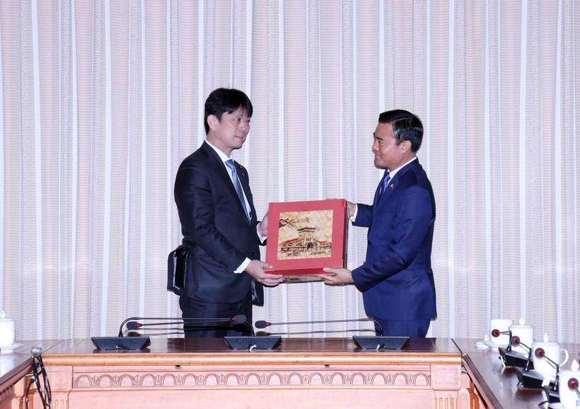 Phó Chủ tịch Ủy ban Nhân dân Thành phố Hồ Chí Minh Bùi Xuân Cường (phải) trao quà đối ngoại cho Thứ trưởng Bộ Ngoại giao Nhật Bản Komura Masahiro. (Ảnh: Xuân Khu/TTXVN)