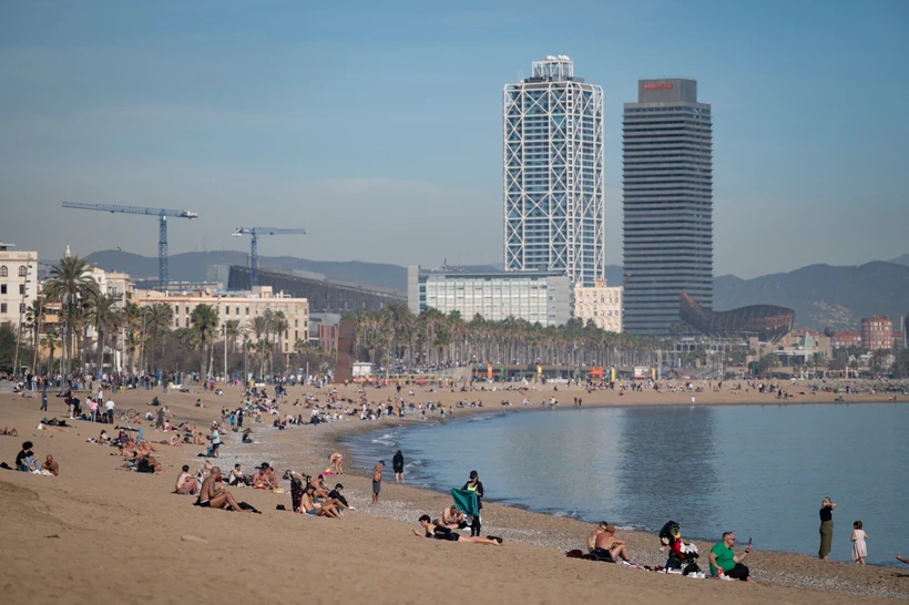 Người dân tắm mát trên bãi biển ở Barcelona, Tây Ban Nha. (Ảnh: AFP/TTXVN)