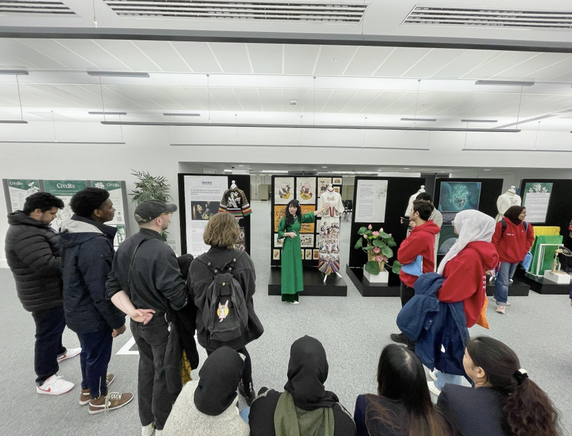 Tiến sỹ Trần Mai Khanh (áo xanh) giới thiệu với người xem về cách tiếp cận chất liệu trong thời trang bền vững. (Ảnh: TTXVN phát)