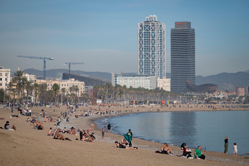 Người dân tắm mát trên bãi biển ở Barcelona, Tây Ban Nha. (Ảnh: AFP/TTXVN)