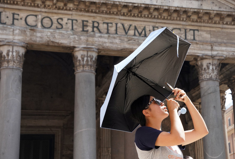 Du khách che ô khi di chuyển trong nắng gắt tại Rome, Italy ngày 18/7/2023. (Ảnh: THX/TTXVN)