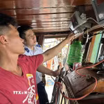 Kiểm tra thiết bị giám sát hành trình trên tàu cá. (Ảnh: TTXVN phát)