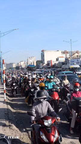 Nhiều người đi xe máy chạy lên vỉa hè để di chuyển khi đường ùn ứ. (Ảnh: Tiến Lực/TTXVN)