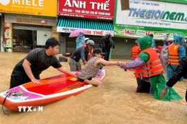 Sử dụng thuyền kayak đưa người dân vùng ngập lụt bị cô lập đến nơi an toàn. (Ảnh: Phan Sáu/TTXVN)