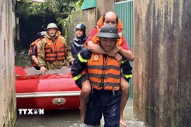 Tổ công tác gồm 10 cán bộ, chiến sỹ tiếp cận hiện trường, đưa xuồng cứu nạn cứu hộ vào các điểm ngập sâu, tổ chức di dời 6 hộ dân với khoảng 10 nhân khẩu, trong đó có người già, trẻ nhỏ và phụ nữ mang thai, ra khỏi khu vực nguy hiểm đến nơi an toàn. (Ảnh: TTXVN phát)