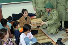 Chủ tịch Ủy ban Nhân dân tỉnh Quảng Ngãi Nguyễn Hoàng Giang thăm, tặng quà ở điểm tập kết người dân tránh bão số 13 tại Trường Tiểu học, Trung học cơ sở Đức Lợi. (Ảnh: Cao Nguyên/TTXVN)