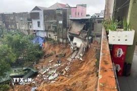 Phần móng của nhiều ngôi nhà cao tầng có nguy cơ tiếp tục sạt lở xuống vực sâu. (Ảnh: TTXVN phát)