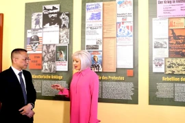 Bà Claudia Opitz, một trong ba người tổ chức "VIETNAM 75" giới thiệu với Tham tán Công sứ Chu Tuấn Đức về triển lãm. (Ảnh: Thu Hằng/TTXVN)