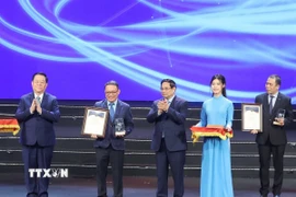 Thủ tướng Phạm Minh Chính và ông Nguyễn Trọng Nghĩa, Ủy viên Bộ Chính trị, Bí thư Trung ương Đảng, Chủ nhiệm Tổng cục Chính trị Quân đội Nhân dân Việt Nam trao Giải Nhất cho nhóm tác giả Nhà xuất bản Thông tấn-Thông tấn xã Việt Nam. (Ảnh: Phương Hoa/TTXVN)