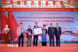 Lãnh đạo Sở Văn hóa, Thể thao và Du lịch tỉnh Điện Biên, lãnh đạo xã Mường Nhé trao Giấy Chứng nhận Di sản Văn hóa Phi vật thể Quốc gia “Lễ mừng cơm mới của người Si La” cho chủ thể di sản văn hóa. (Ảnh: TTXVN phát)
