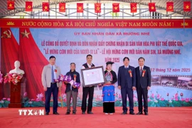 Lãnh đạo Sở Văn hóa, Thể thao và Du lịch tỉnh Điện Biên, lãnh đạo xã Mường Nhé trao Giấy Chứng nhận Di sản Văn hóa Phi vật thể Quốc gia “Lễ mừng cơm mới của người Si La” cho chủ thể di sản văn hóa. (Ảnh: TTXVN phát)