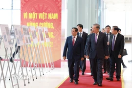 Tổng Bí thư Tô Lâm và Thủ tướng Phạm Minh Chính cùng các đại biểu tham quan trưng bày ảnh về hoạt động của Chính phủ qua các thời kỳ do TTXVN thực hiện. (Ảnh: Dương Giang/TTXVN)