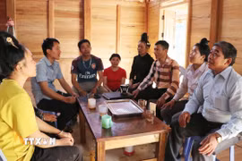 Bí thư Chi bộ Lý Văn Chém (áo sọc) rất được bà con người Cống ở bản Táng Ngá tín nhiệm. (Ảnh: Nguyễn Oanh/TTXVN)