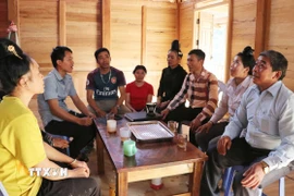 Bí thư Chi bộ Lý Văn Chém (áo sọc) rất được bà con người Cống ở bản Táng Ngá tín nhiệm. (Ảnh: Nguyễn Oanh/TTXVN)