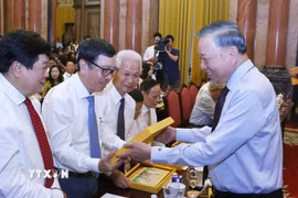 Tổng Bí thư, Chủ tịch nước Tô Lâm tặng quà lưu niệm cho các nhà báo tiêu biểu. (Ảnh: Văn Điệp/TTXVN)