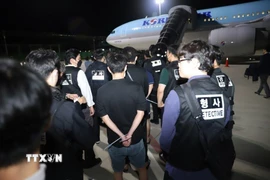 Các công dân nước ngoài liên quan hoạt động lừa đảo sử dụng công nghệ được bàn giao tại sân bay quốc tế ở thủ đô Phnom Penh, Vương quốc Campuchia, tối 17/10/2025. (Ảnh: AKP/TTXVN phát)