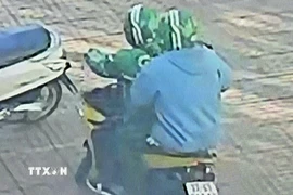 Các đối tượng dùng súng cướp ngân hàng. (Ảnh chụp màn hình camera. TTXVN phát)