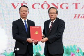 Ông Hoàng Đăng Quang, Phó Trưởng ban Thường trực Ban Tổ chức Trung ương trao quyết định cho ông Phan Thiên Định. (Ảnh: Công Tường/TTXVN)