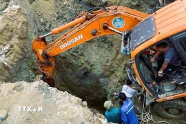 Nỗ lực ứng cứu các nạn nhân trong vụ tai nạn thương tâm. (Ảnh: TTXVN phát)