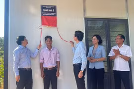 Đại diện lãnh đạo tỉnh Bình Phước và huyện Bù Đăng bàn giao nhà ở cho hộ dân nghèo. (Ảnh: TTXVN phát)