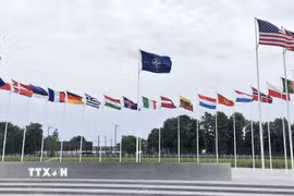 Cờ NATO và quốc kỳ các nước thành viên bên ngoài trụ sở liên minh quân sự ở Brussels, Bỉ. (Ảnh: AA, Kyodo/TTXVN phát)