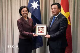 GS.TS Nguyễn Xuân Thắng tặng quà lưu niệm cho đại diện Trường Quản trị Australia và New Zealand. (Ảnh: Diệu Linh/TTXVN)