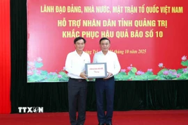 Ông Trần Cẩm Tú, Ủy viên Bộ Chính trị, Thường trực Ban Bí thư thay mặt lãnh đạo Đảng, Nhà nước trao kinh phí hỗ trợ nhân dân tỉnh Quảng Trị. (Ảnh: Phương Hoa/TTXVN)
