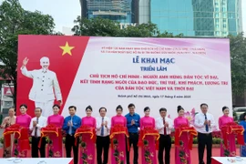 Các đại biểu thực hiện nghi thức khai mạc triển lãm. (Ảnh: Thu Hương/TTXVN)