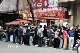 Người dân xếp hàng dài chờ mua vàng tại cửa hàng Bảo Tín Minh Châu trên phố Trần Nhân Tông, Hà Nội, dù có thông báo tạm hết hàng. (Ảnh: Trần Việt/TTXVN)