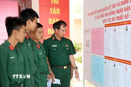 Các chiến sỹ xem kỹ danh sách người ứng cử. (Ảnh: Công Thử/TTXVN)