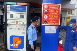 Lực lượng quản lý thị trường thành phố Đà Nẵng triển khai dán thông báo số điện thoại đường dây nóng, tại các cửa hàng xăng, dầu. (Ảnh: Trần Tĩnh/TTXVN)