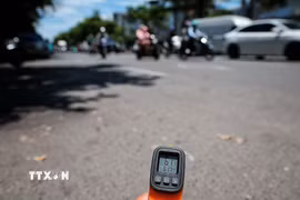 Thiết bị đo nhiệt cho thấy nhiệt độ bề mặt mặt đường ngoài trời lên tới hơn 61 độ C vào thời điểm giữa trưa ngày 25/5. (Ảnh: Phạm Tuấn Anh/TTXVN)