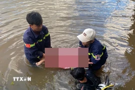 Lực lượng chức năng tìm thấy thi thể 2 em nhỏ đuối nước ở hồ Bến Sanh. (Ảnh: TTXVN phát)