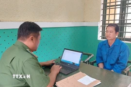 Lực lượng công an làm việc với bị can Nguyễn Việt Thanh. (Ảnh: TTXVN phát)