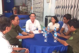 Ông Nguyễn Hoài Trung, Bí thư Chi bộ, Trưởng khu phố 3, xã Đức Hòa, tỉnh Tây Ninh đang trao đổi cùng tổ an ninh tự quản. (Ảnh: Thanh Bình/TTXVN)