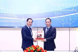 Chánh Văn phòng Trung ương Đảng Nhân dân Cách mạng Lào Thongsalith Mangnomek trao quà lưu niệm cho ông Lê Hoài Trung, Chánh Văn phòng Trung ương. (Ảnh: Phương Hoa/TTXVN)