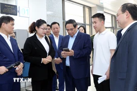 Thủ tướng Phạm Minh Chính ghi nhận đánh giá chất lượng dịch vụ công từ người dân. (Ảnh: Văn Đức/TTXVN)