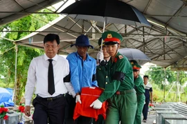 Bí thư Tỉnh ủy Kiên Giang Nguyễn Tiến Hải đưa hài cốt liệt sỹ về nơi an táng. (Ảnh: Văn Sĩ/TTXVN)