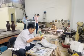 Nghệ nhân làng nghề Chuyên Mỹ đam mê tạo ra những tác phẩm khảm trai sơn mài và giữ ngọn lửa nghề cho quê hương. (Ảnh: Tuyết Mai/TTXVN)